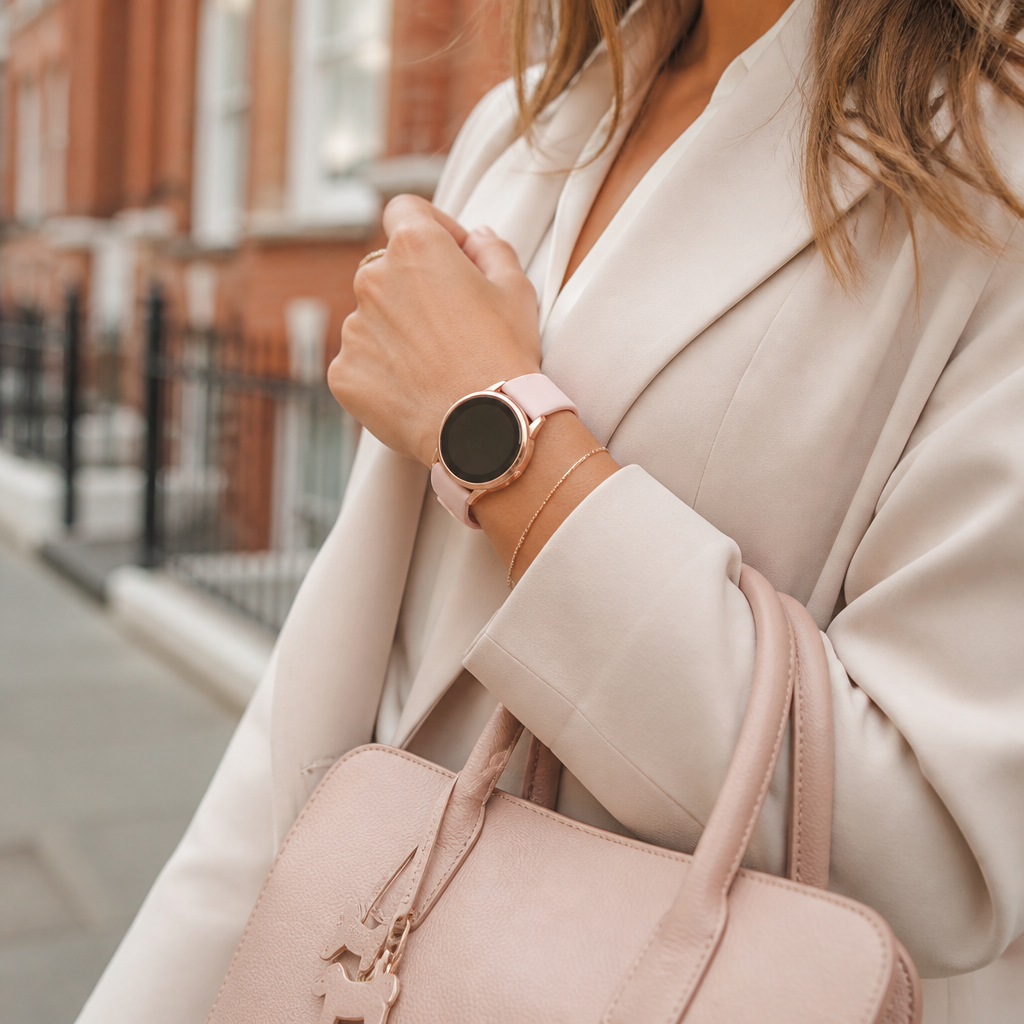 A woman's wrist wearing a stylish watch while she holds a leather handbag.